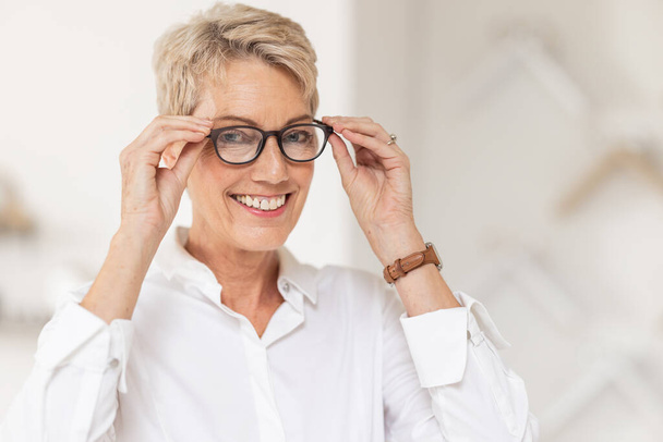 Lunettes, vision et optométrie avec une cliente chez l'opticien qui achète de nouvelles lunettes de vue. Portrait, lunettes et vente au détail avec une consommatrice achetant des lentilles de prescription chez un optométriste. - Photo, image