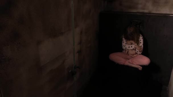 Megijedt lány egy babával egy sötét szobában. Kiváló minőségű 4k felvételek - Felvétel, videó