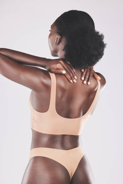 Schoonheid, rug en lingerie van zwarte vrouw in studio voor huidverzorging, verzorging en hygiëne op een grijze achtergrond. Wellness, meisje en nigeriaans model ontspannen met verwennen, massage en huidbehandeling met mockup. - Foto, afbeelding
