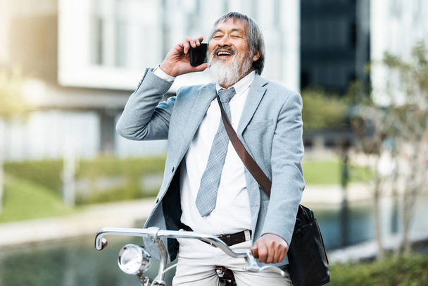 Phone call, businessman and cycling asian man on a trip or journey to work in the city during the day. Cycle, bike and bicycle with male businessperson on cellphone communication during urban commute. - Fotografie, Obrázek