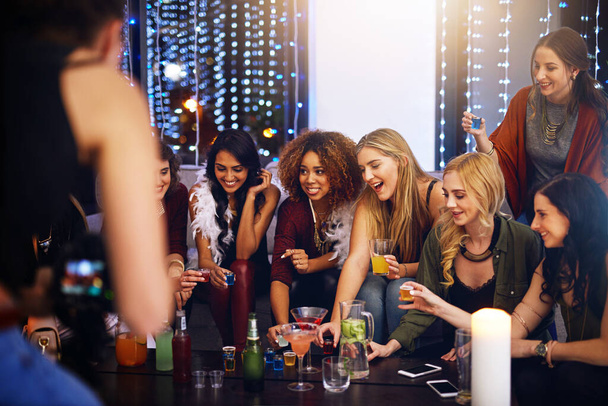 Taking a round with the girls. a group of friends having shots together at a party - 写真・画像