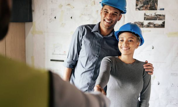 Handshake, engineering and architect in a b2b partnership deal with a successful industrial company. Smile, hiring and happy woman in leadership shaking hands with a construction worker for a new job. - Photo, Image