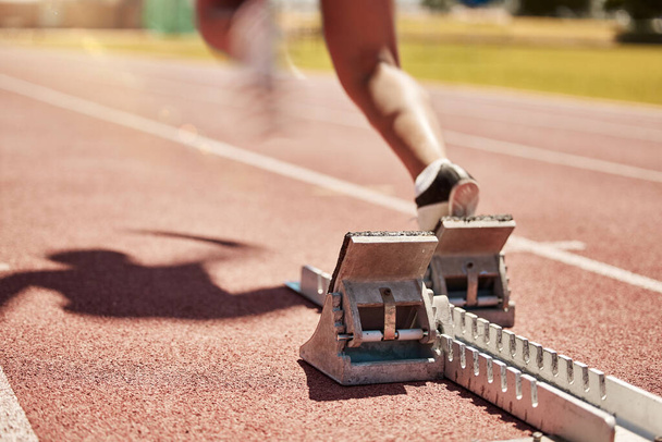 Sports, fitness and running with a start block on a track for a competitive race in a stadium or arena. Health, workout and exercise shoes with a runner at the beginning of a sport competition. - Fotoğraf, Görsel