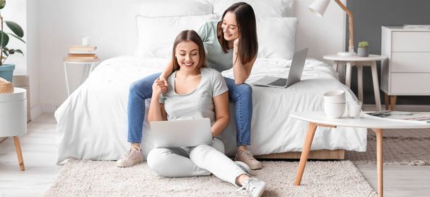 Jovem casal lésbico com laptop no quarto - Foto, Imagem