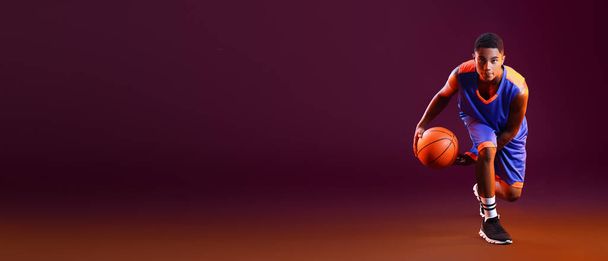 Junge afroamerikanische Basketballspielerin auf dunklem Hintergrund mit Platz für Text - Foto, Bild