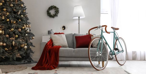 Wnętrze lekkiego salonu z rowerem, sofą i choinką - Zdjęcie, obraz