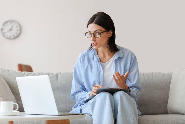 Psicóloga feminina vídeo conversando com paciente no sofá em casa - Foto, Imagem