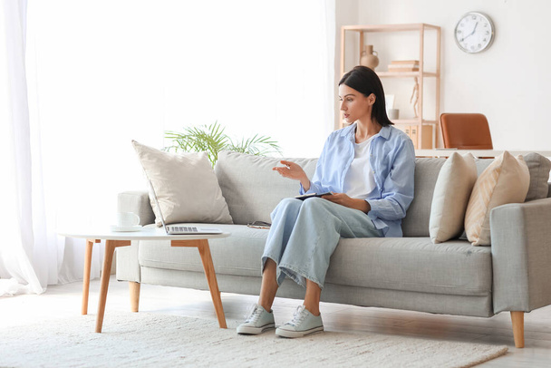 Kobieta psycholog wideo czat z pacjentem na kanapie w domu - Zdjęcie, obraz