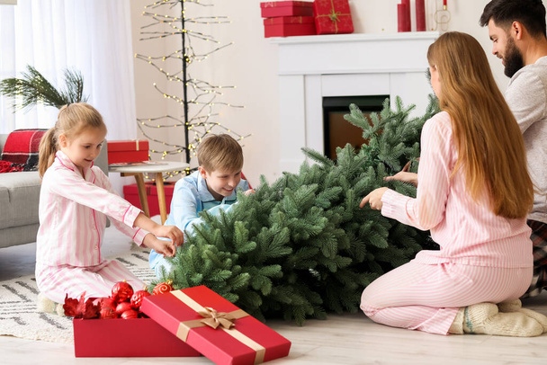 Pais felizes e seus filhos pequenos com árvore de Natal em casa - Foto, Imagem
