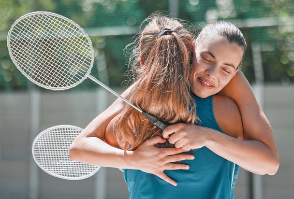Badminton, sukces i przyjaciele przytulić po meczu sportowym lub gra szkoleniowa dla wsparcia, miłość i gratulacje. Fitness, uśmiech i szczęśliwe kobiety przytulające się z okazji pracy zespołowej w konkursie dziewczęcym. - Zdjęcie, obraz