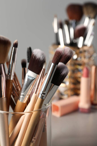 Set of professional makeup brushes on grey table, closeup - Fotó, kép