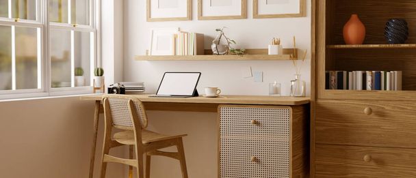 Skandynawskie i komfortowe wnętrze pokoju pracy z tabletem i wystrojem na drewnianym stole w pobliżu okna, drewniane krzesło, drewniana półka, biała ściana i wystrój domu. 3d renderowanie, ilustracja 3d - Zdjęcie, obraz