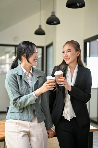 Ritratto, Due belle e attraenti donne d'affari asiatiche millenarie amano chiacchierare durante la loro pausa caffè in ufficio. - Foto, immagini