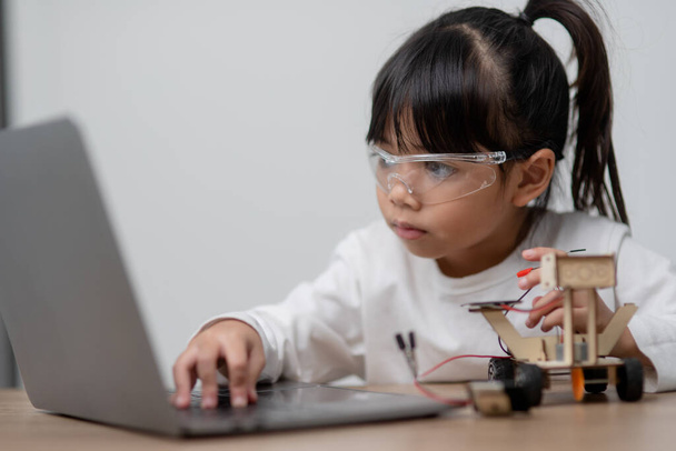 Ασία φοιτητές μαθαίνουν στο σπίτι στην κωδικοποίηση ρομπότ αυτοκίνητα και ηλεκτρονικά καλώδια του σκάφους σε STEM, STEAM, μαθηματικά μηχανικής τεχνολογίας κώδικα υπολογιστών στην ρομποτική για τα παιδιά έννοια. - Φωτογραφία, εικόνα