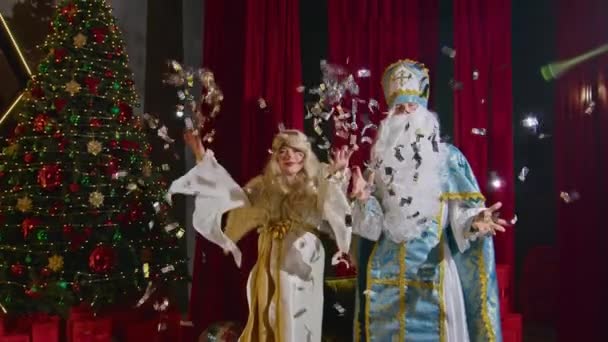 Санта и миссис Санта желают счастливого Рождества, дарят подарки и украшают елку. - Кадры, видео