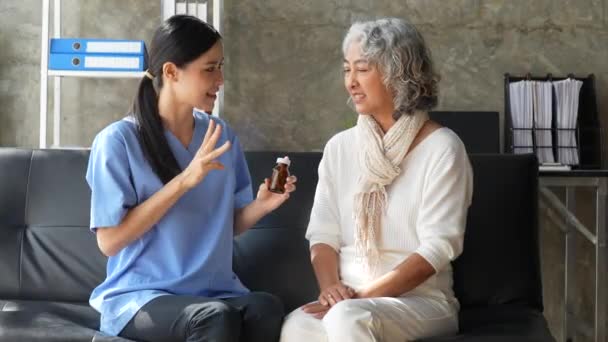 Thuis gezondheidszorg verpleegkundige, fysiotherapie met oudere volwassen vrouw thuis. - Video