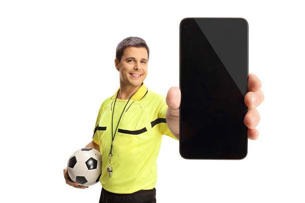Piłka nożna sędzia trzyma piłkę i pokazuje smartfon odizolowany na białym tle - Zdjęcie, obraz