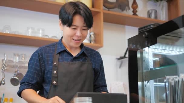 Happy tomboy barista za pomocą ekranu dotykowego kasjer otrzymuje zamówienie do klienta w kawiarni. Usługi dla przedsiębiorstw. - Materiał filmowy, wideo