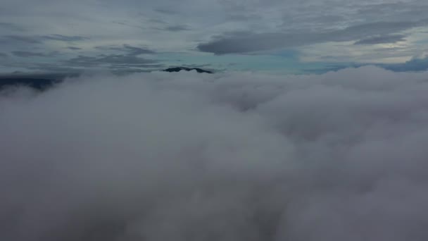 A felhő felett az erdő és a kis falvak látványa látható madártávlatból. Ezt a videót 2021. szeptemberében vették fel Tak tartományból.. - Felvétel, videó