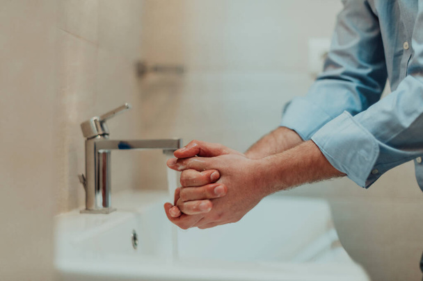 Mann mit Seife und Händewaschen unter dem Wasserhahn. Hygiene-Konzept Hand Nahaufnahme Detail. Hochwertiges Foto - Foto, Bild