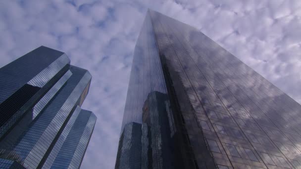 Nuvens são refletidas em um arranha-céu de vidro espelhado em um distrito de negócios. Negócios corporativos, superfície de vidro de arranha-céu alto. Desfasamento temporal. Imagens 4k de alta qualidade - Filmagem, Vídeo
