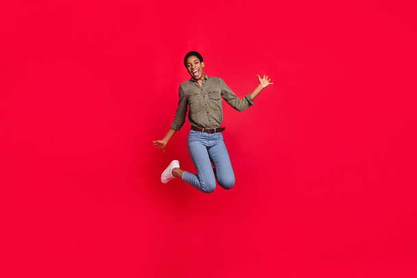 Full length body size view of attractive cheerful girl jumping good mood isolated over vivid red color background. - Фото, изображение