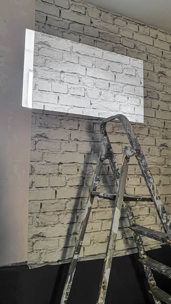 Reparación en un edificio residencial. En la pared hay papel con un patrón de ladrillo, pintura, yeso. enfoque selectivo - Foto, Imagen