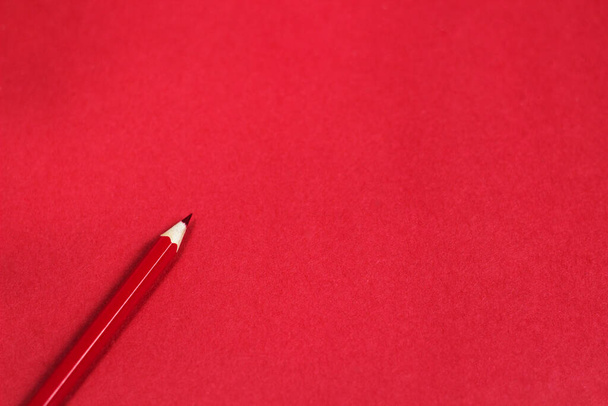 Kırmızı kağıda koyulan tahta kırmızı kalem renginin üst görünüm fotoğrafıyla kopyalama alanı olan şablon  - Fotoğraf, Görsel