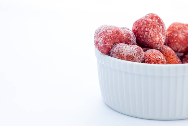 frozen strawberries in white ceramic bowl on white background with copy space  - Photo, Image