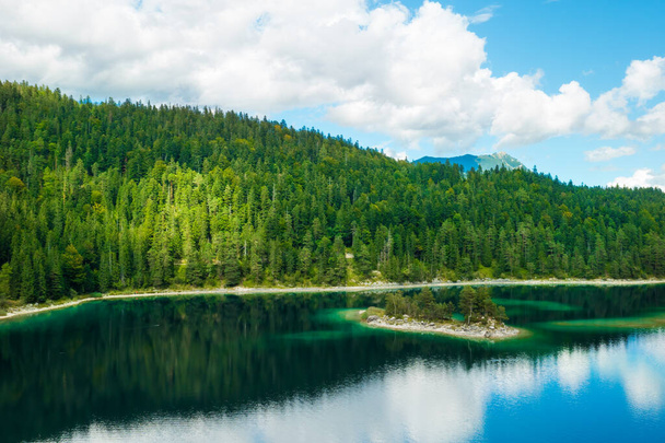 スプルースの木と雲を持つ山は森林川に反映されます。川沿いの夏の風景.  - 写真・画像