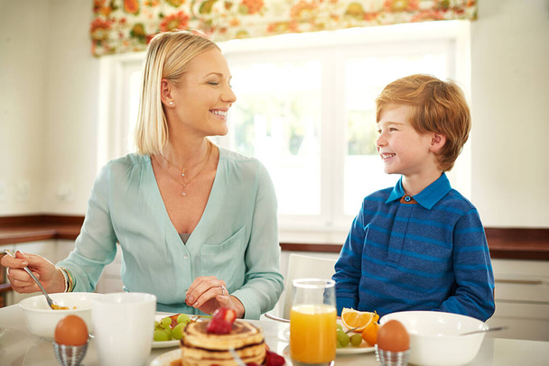 栄養価の高いおいしい朝食を一緒に共有する。お母さんと息子が家で一緒に朝食を楽しんでる - 写真・画像