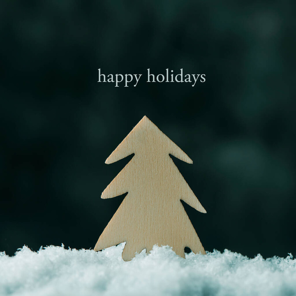 close-up de um abeto recortado em madeira na neve e o texto férias felizes - Foto, Imagem
