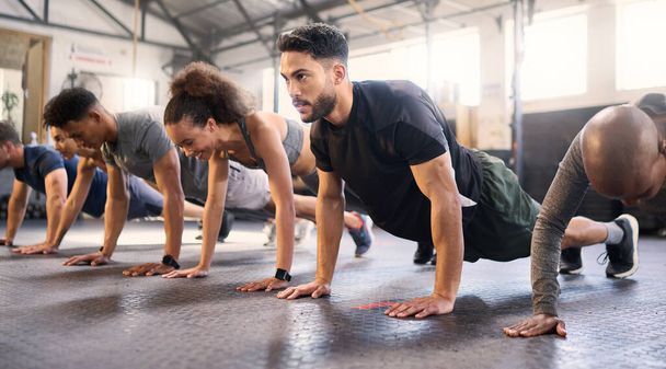 Fitness, tělocvična s muži a ženami dělá prkno, silný a cvičení pro svalové, kardio a vytrvalost ve třídě cvičení. Zdraví, wellness a rozmanitost, tělesná výchova a zdravá aktivní výzva - Fotografie, Obrázek