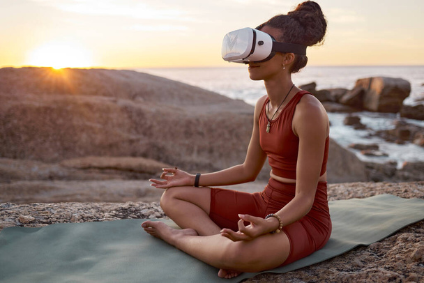 Woman, metaverse or vr headset in yoga meditation by beach, ocean waves, sea water in mental health support, zen app or 3d peace ai. Lotus, relax or wellness person on virtual reality chakra software. - Photo, Image
