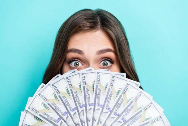 Closeup photo of young excited positive cute lady hiding face much cash dollars playful childish rich successful business isolated on aquamarine color background. - Fotó, kép