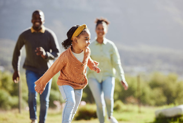 Black family, fun child and parents running, chasing and enjoy bonding quality time with youth kid on countryside vacation. Love, peace and freedom for happy girl, father and mother playing outdoor. - Valokuva, kuva