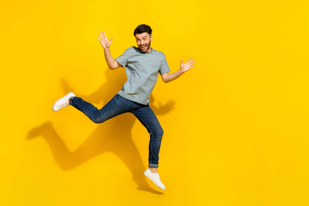 Full body portrait of satisfied glad person jumping raise hands empty space isolated on yellow color background. - Foto, Imagem