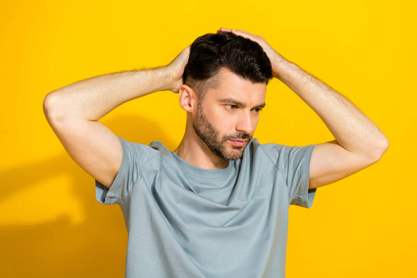 Photo of young serious macho boyfriend man touching his hairstyle no dander solution good mood advertisement isolated on yellow color background. - Fotografie, Obrázek