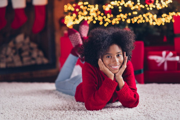 Photo of cheerful adorable dreamy child teenager wear red jumper two hands touch cheeks lying floor have relax rest weekend cozy evening. - Foto, afbeelding