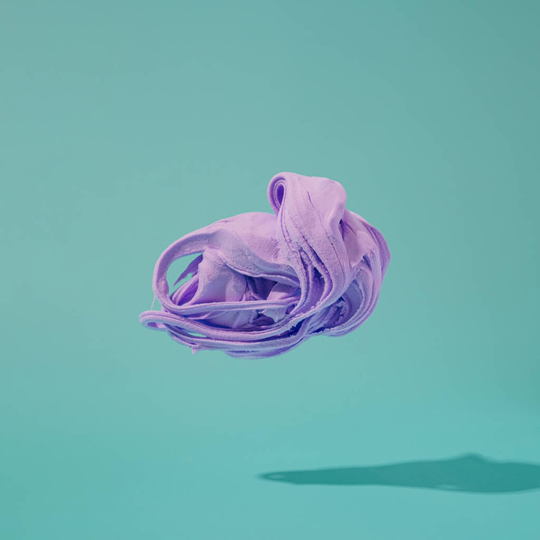Cloud shaped soft clay on a teal background. Violet abstract minimal concept. - Photo, Image