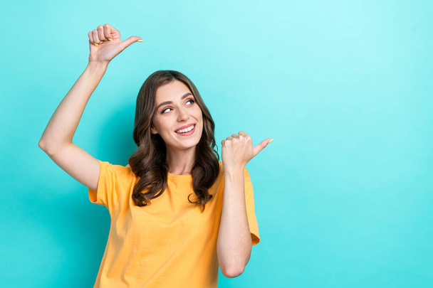 Photo of young gorgeous nice woman wear yellow t-shirt fingers pointing empty space look interested information isolated on cyan color background. - Фото, зображення