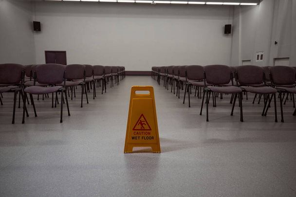 Nincs fénykép sárga figyelmeztető tábláról egy székekkel teli szoba közepén. - Fotó, kép
