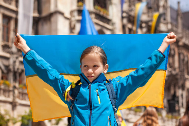 Protestní pochod proti válce. Girl Child Holding Ukraine Flag on Rally to Support Ukraine in Marienplatz in Munich Germany - Fotografie, Obrázek