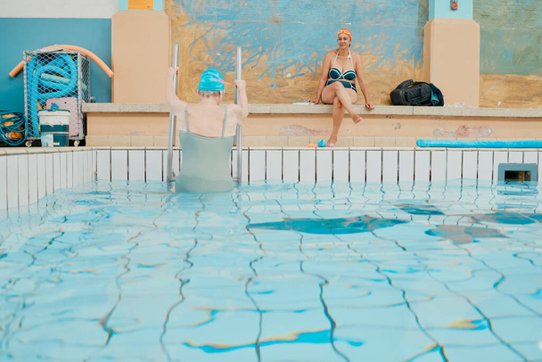 Swimmer, swimming pool and woman leaving water after fun swim, aquatic exercise and training for fitness workout at a spa. Elderly friends, relax and enjoy swimming for health in indoor pool together. - Foto, Imagem