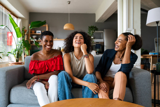 Happy beautiful hispanic south american and black women meeting indoors and having fun - Black adult females best friends spending time together, concepts about domestic life, leisure, friendship and togetherness - 写真・画像