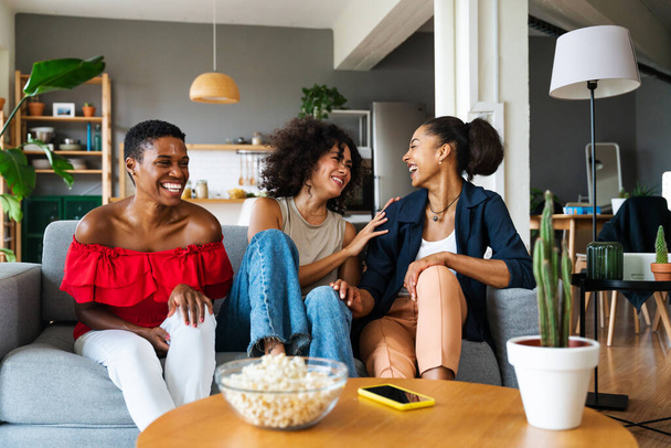 Happy beautiful hispanic south american and black women meeting indoors and having fun - Black adult females best friends spending time together, concepts about domestic life, leisure, friendship and togetherness - Foto, afbeelding