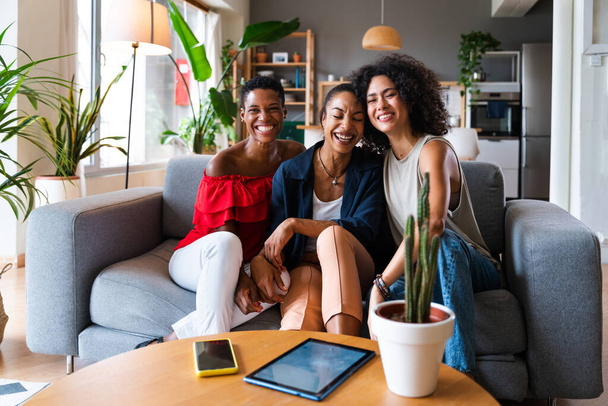 Happy beautiful hispanic south american and black women meeting indoors and having fun - Black adult females best friends spending time together, concepts about domestic life, leisure, friendship and togetherness - Photo, Image