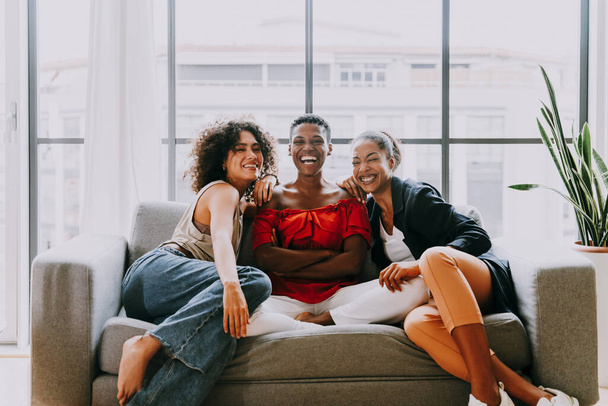 Happy beautiful hispanic south american and black women meeting indoors and having fun - Black adult females best friends spending time together, concepts about domestic life, leisure, friendship and togetherness - 写真・画像
