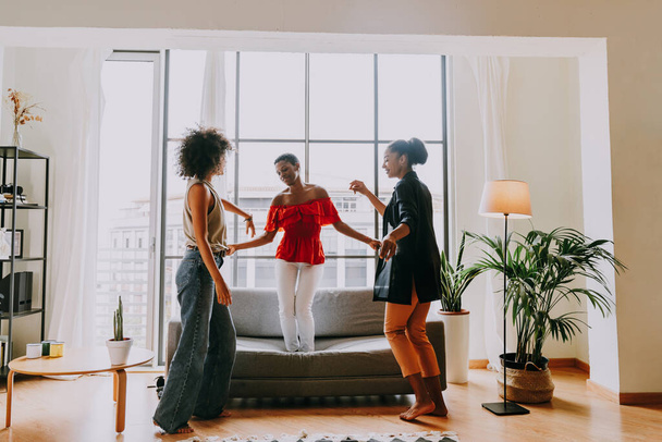 Happy beautiful hispanic south american and black women meeting indoors and having fun - Black adult females best friends spending time together, concepts about domestic life, leisure, friendship and togetherness - Фото, зображення