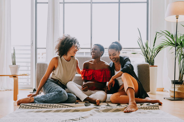 Happy beautiful hispanic south american and black women meeting indoors and having fun - Black adult females best friends spending time together, concepts about domestic life, leisure, friendship and togetherness - Foto, imagen